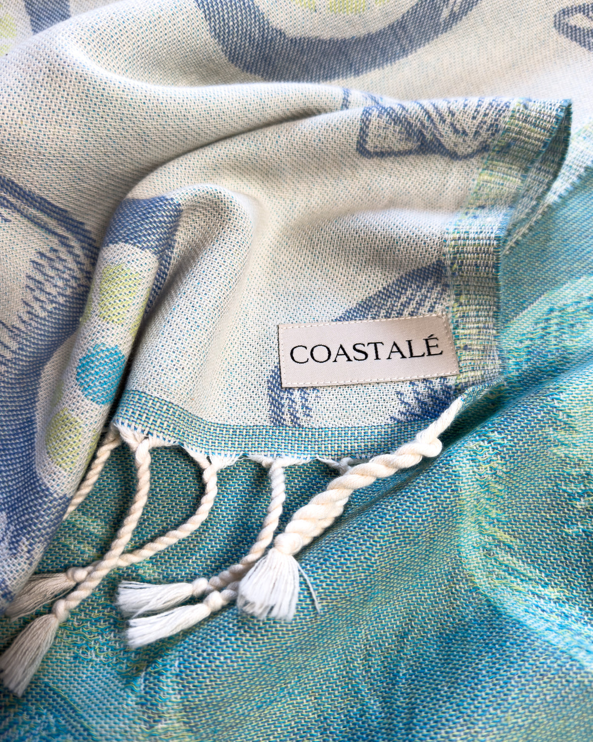 COASTALÉ label on the Charm organic Turkish cotton beach towel. Iconic Turkish Evil Eye, Turquoise.