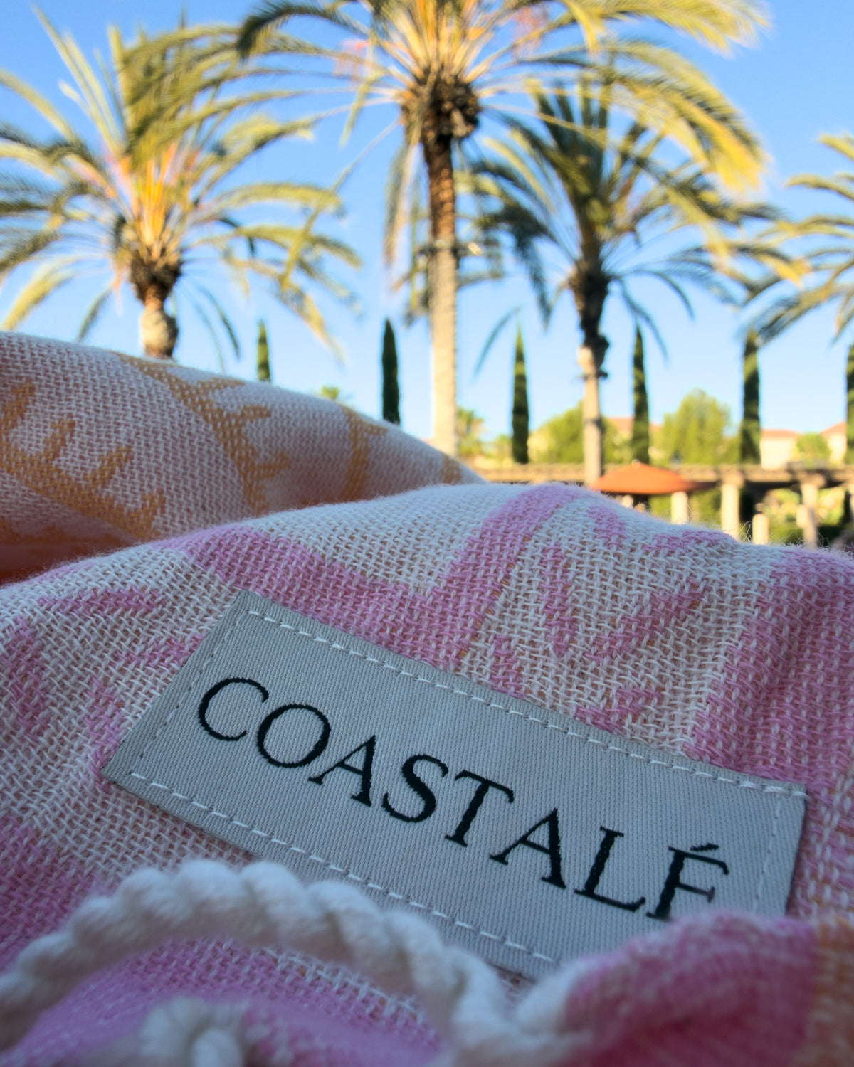 COASTALÉ label on the Shore Treasures organic Turkish cotton beach towel in California beach setting