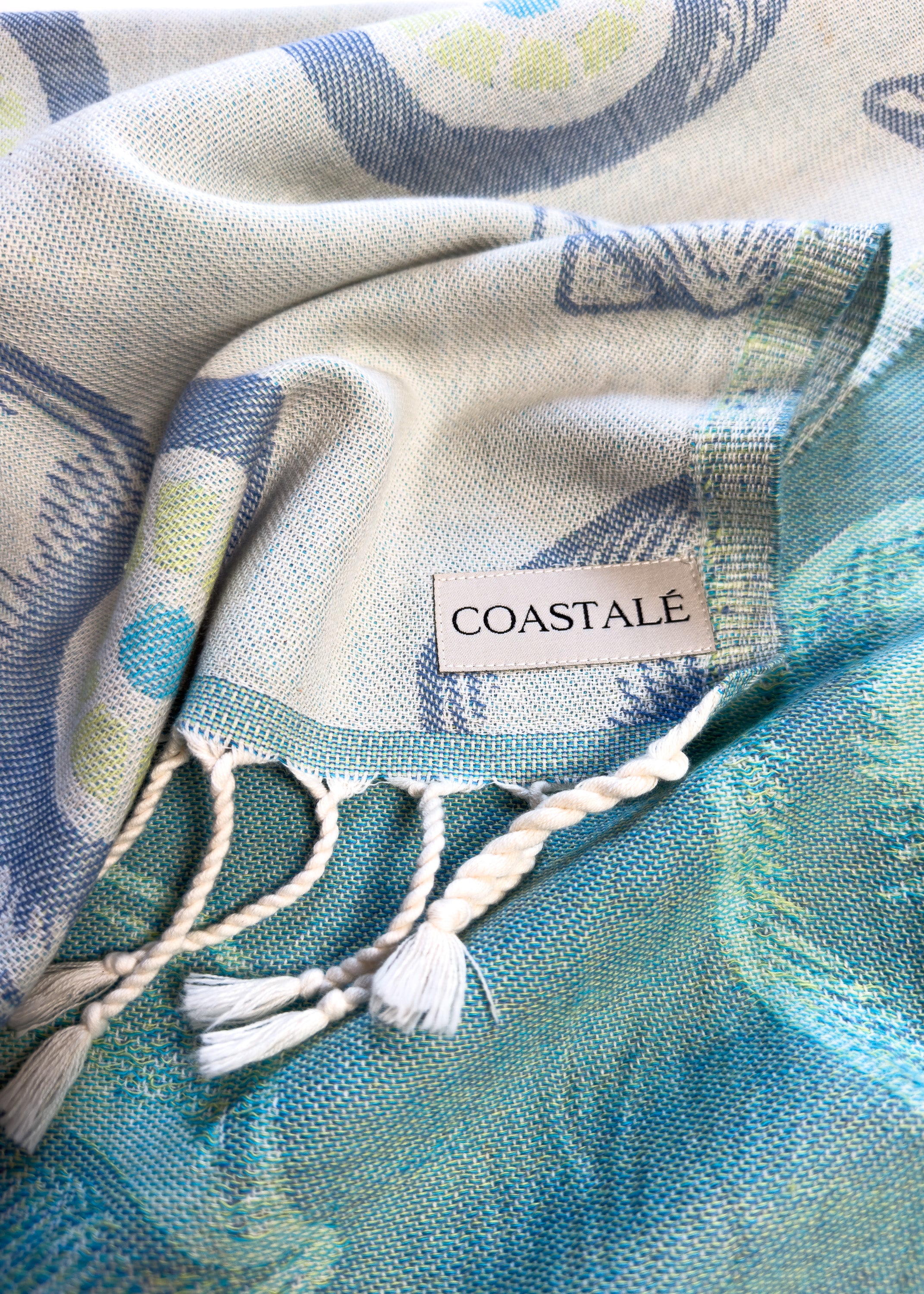 COASTALÉ label on the Charm organic Turkish cotton beach towel. Iconic Turkish Evil Eye, Turquoise.
