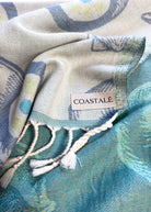 COASTALÉ label on the Charm organic Turkish cotton beach towel. Iconic Turkish Evil Eye, Turquoise.