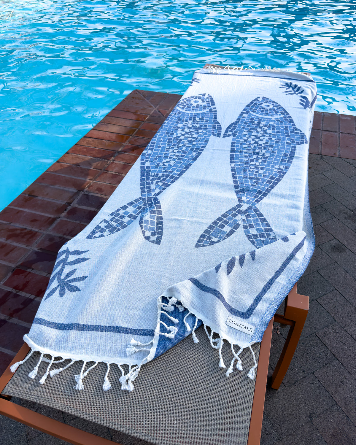 Front view of the Mosaic organic Turkish cotton beach towel in pool view