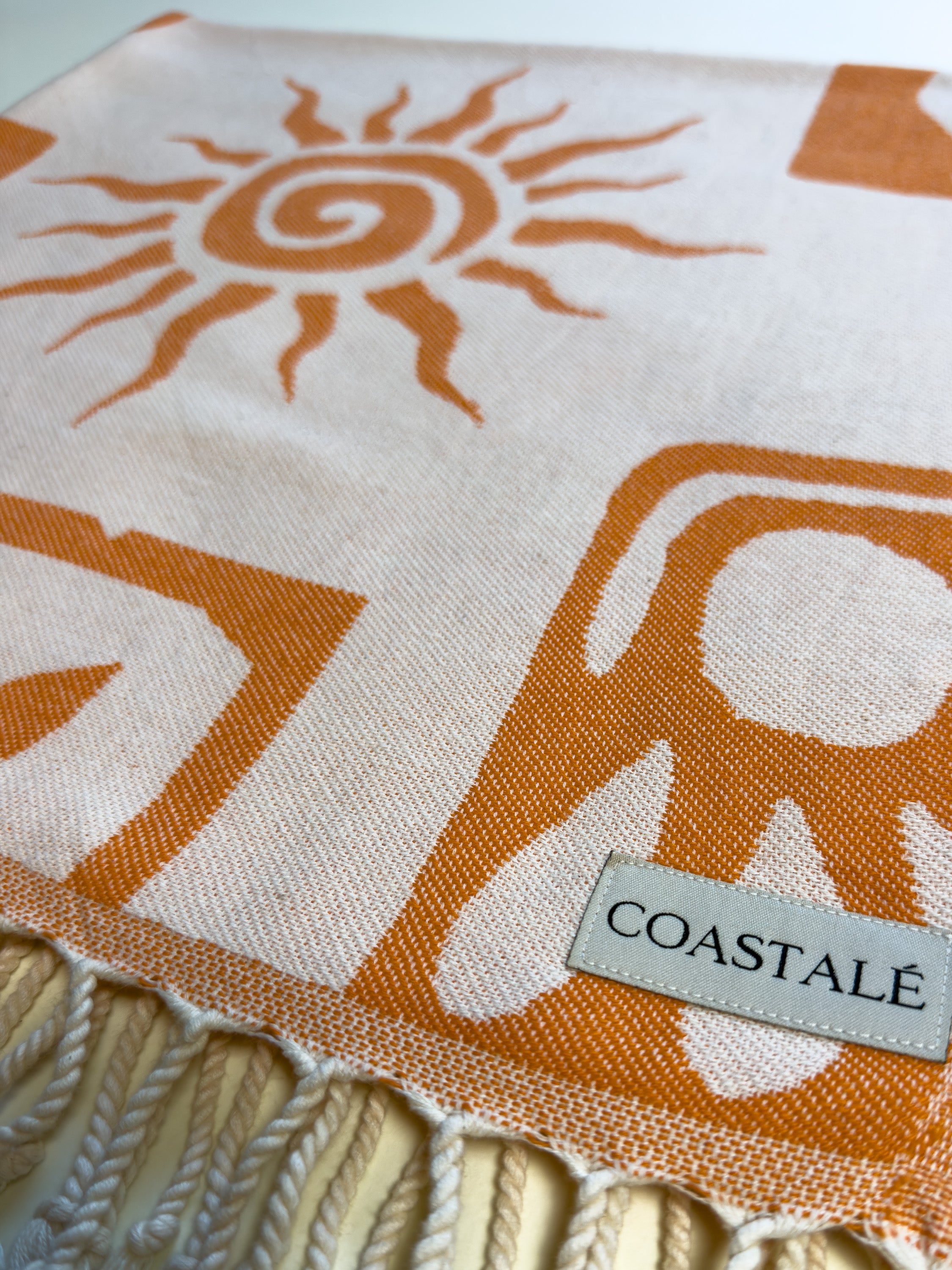 COASTALÉ label on the Postcards orange organic Turkish cotton beach towel